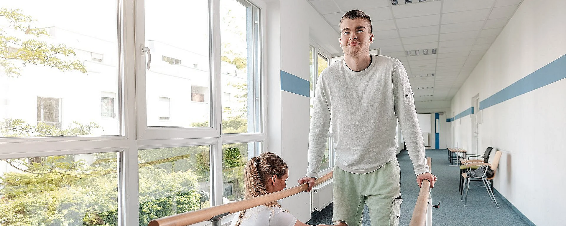 Patient beim Gehtraining mit Physiotherapeutin im Therapiezentrum AKH Celle – Rehabilitation und Mobilitätsförderung nach Verletzung.